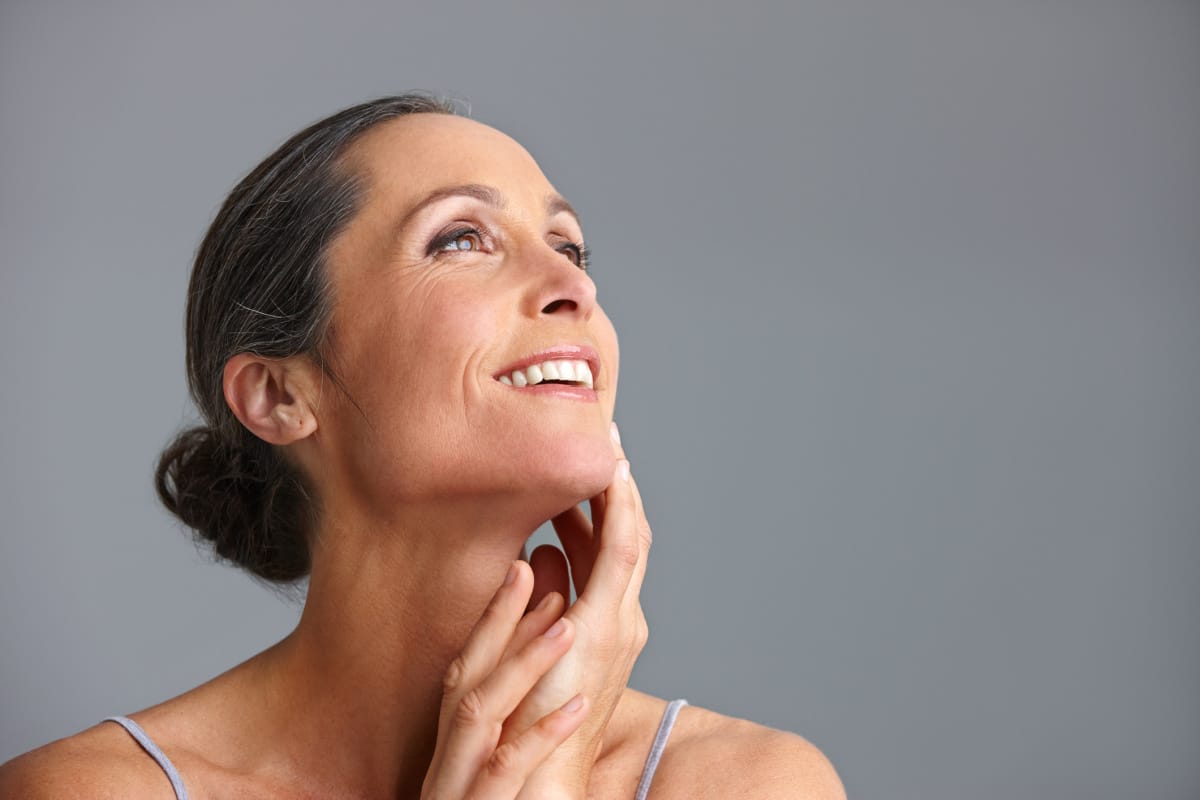 Mature woman touching her hand to her chin and smiling