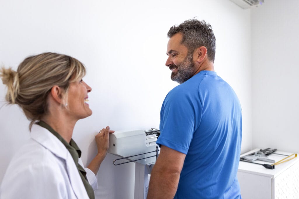 Man on the scale during a medical weight loss check in