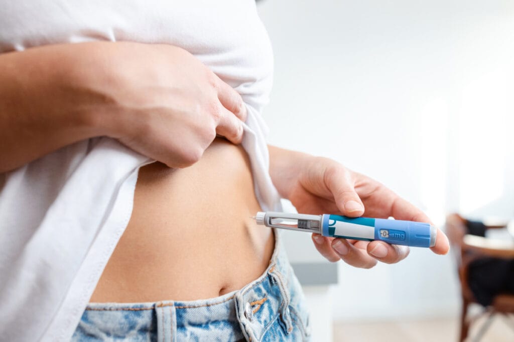 Woman administering weight loss injecton