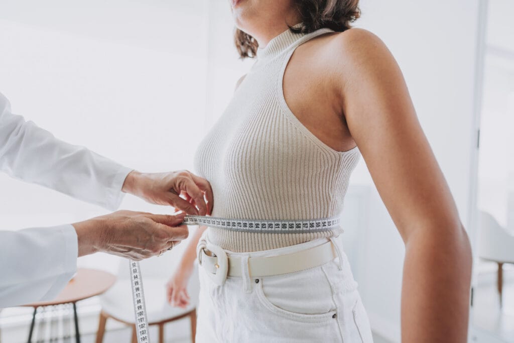 Woman getting measurements taken during medical weight loss appointment